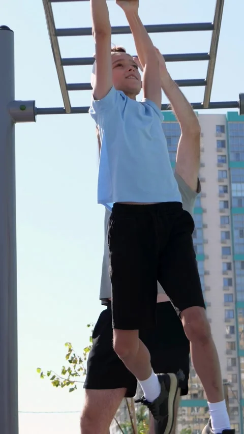 Vertical video of happy father and son playing on playground monkey bars Stock Footage 334994965