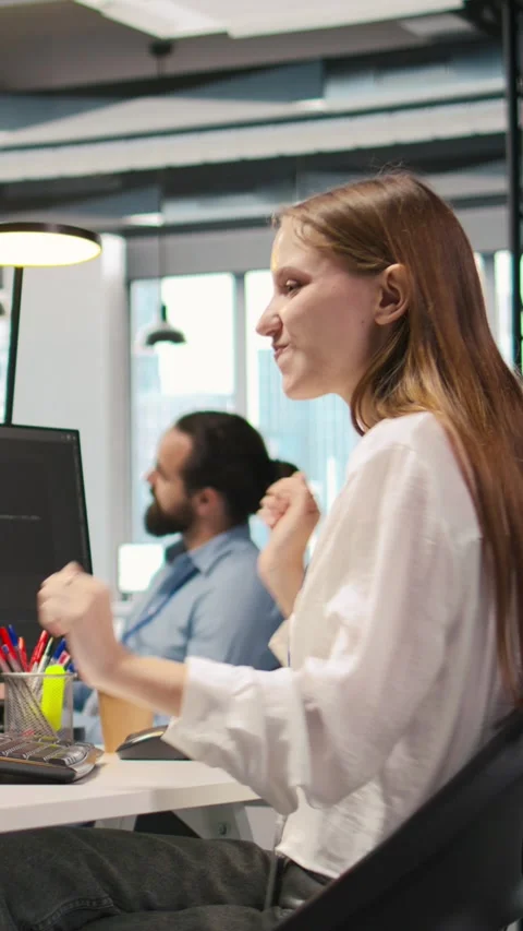Vertical video Happy female programmer dancing on office desk chair Stock Footage 312709396
