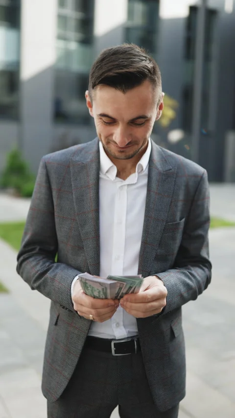 Vertical Video of Happy good looking man in business style holding dollars and Stock Footage 302802313