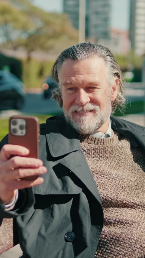 Vertical video, Happy Senior Man Making Video Call in Park Stock Footage 309403647