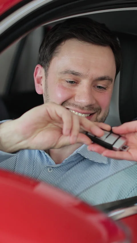 Vertical video Happy young man in the car getting the keys from the dealer. 스톡 동영상 337237521