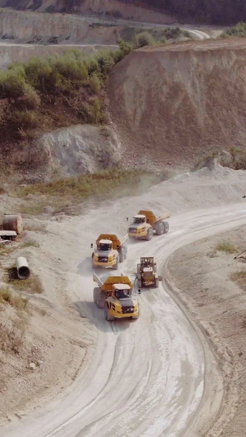 Vertical Video of Heavy Dump Trucks At The Coal Mining Area. The quarry mining Stock Footage 305042923