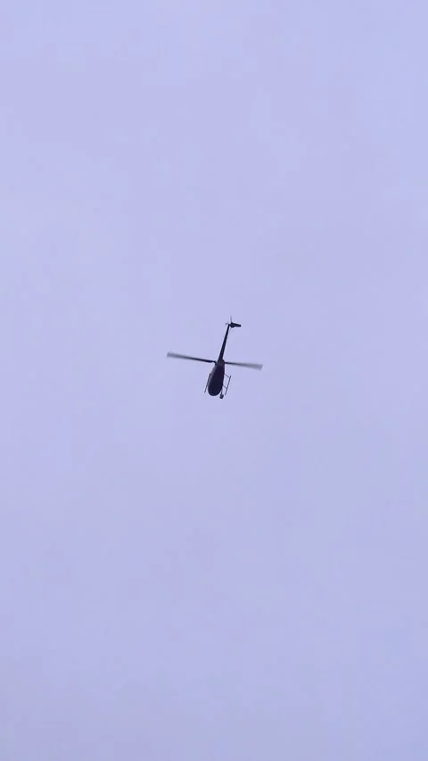 Vertical Video Helicopter Flying in Gray Cloudy Sky Tracking Shot Stock Footage 323399256