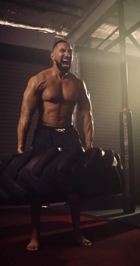 A Vertical Video Of A Hispanic Bodybuilder Doing A Tyre Walk In An MMA Gym Stock Footage 158462670