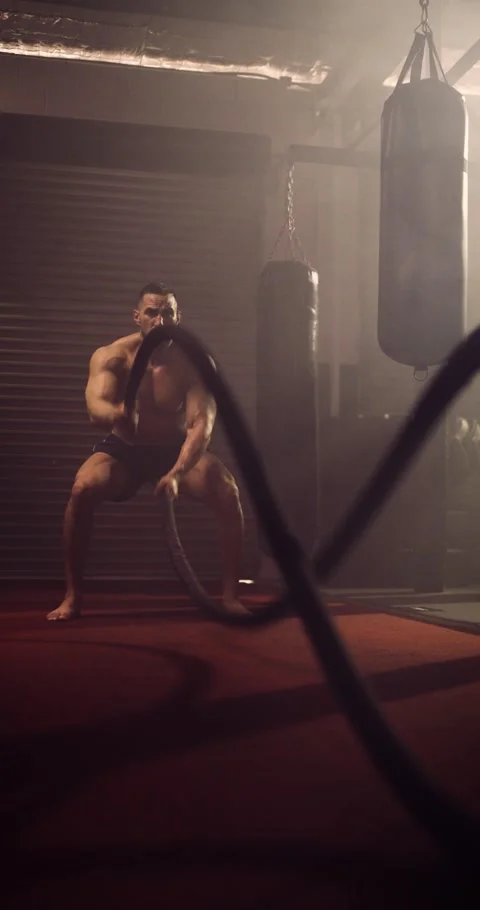 A Vertical Video Of A Hispanic Bodybuilder Exercising Battle Ropes In An MMA Gym Stock Footage 158458721