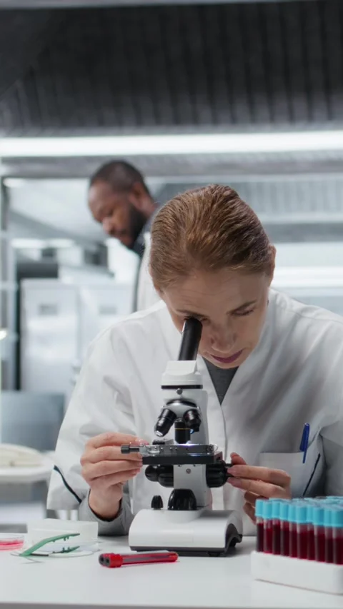 Vertical video Histology technician using compound microscope for detailed 库存影片 326556191