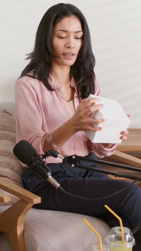 Vertical video: Holding box, host lifting lid and checking contents in studio Stock Footage 348821371