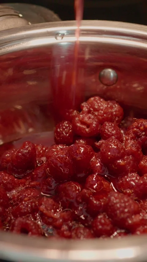 Vertical video Homemade raspberry jam preparation in the cozy kitchen Stock Footage 323361723