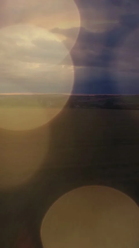 Vertical video: Horizon and storm clouds staying while drifting bokeh revealing Stock Footage 333912862