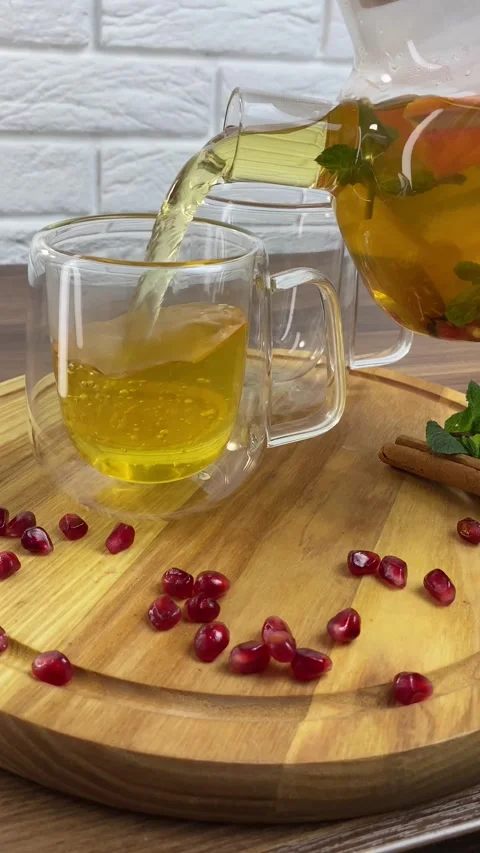 Vertical video: Hot herbal tea with red crandberries poured into glass cup from Stock Footage 265900893