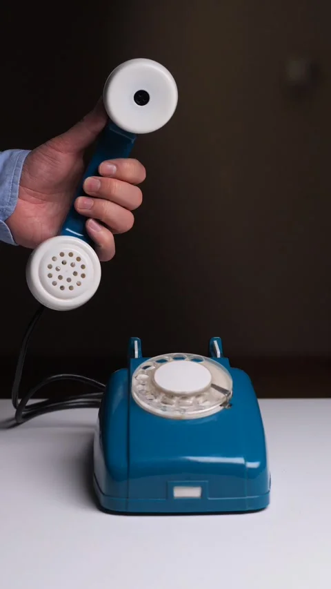Vertical video human hand picking up the receiver from a vintage blue rotary 動画素材 323270205