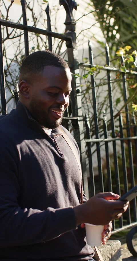 Vertical video: Incoming alert causing African American man scrolling phone Stock Footage 345320832