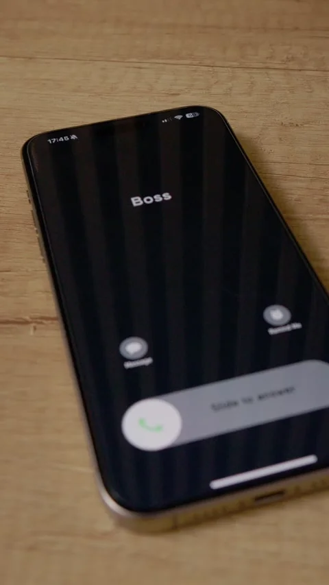 Vertical video Incoming call from Boss on smartphone placed on wooden table Stock Footage 346716029