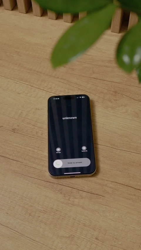 Vertical video Incoming call from unknown number on smartphone on wooden table Stock Footage 346715846