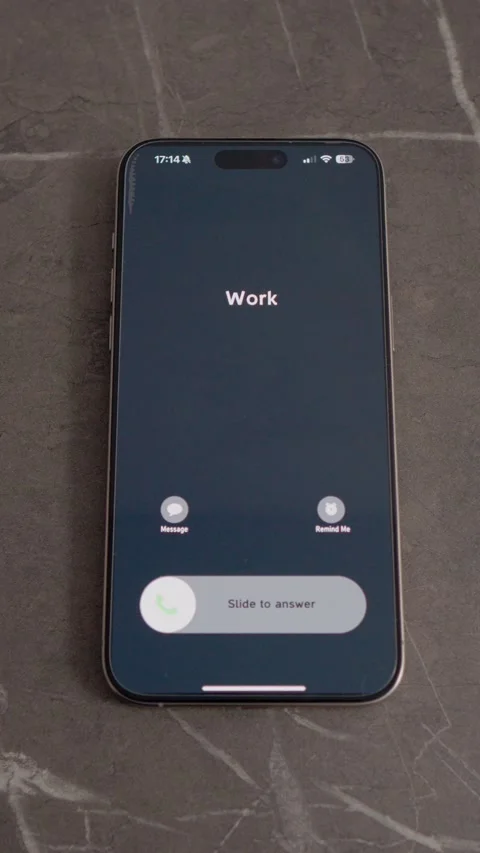 Vertical video Incoming call from work shows up on smartphone at office table Stock Footage 346715588