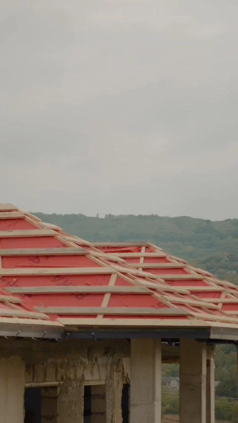 Vertical video Installing wood and anti-condensation foil on a roof during build Video stock 327602289