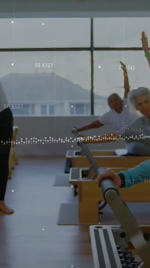 Vertical video: Instructor cueing class stretching on Pilates bar, data Stock Footage 334128078