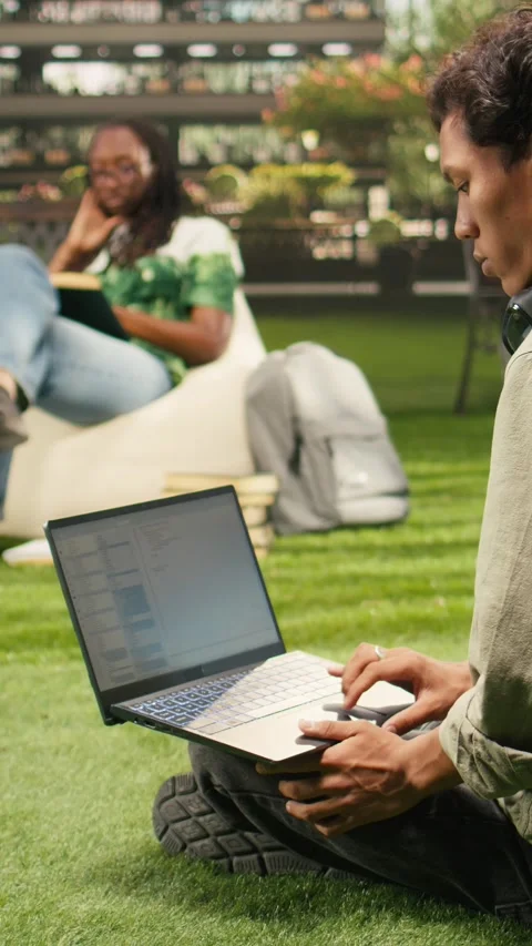 Vertical Video International student using laptop with coding content on campus 動画素材 341321490