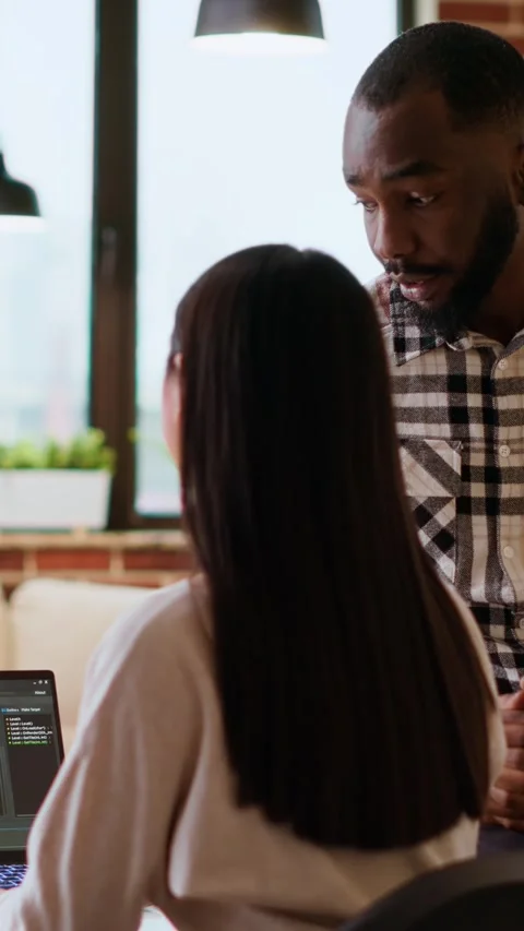 Vertical Video Interracial creative team programing code on a laptop and Stock Footage 319468591