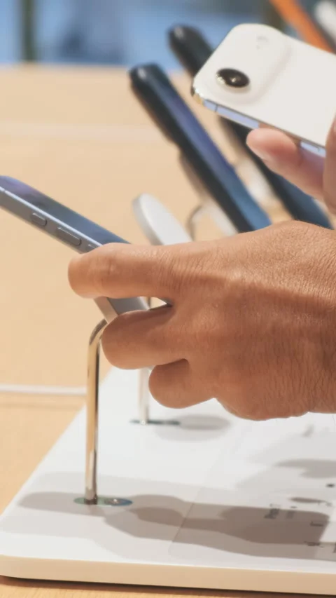 Vertical video: iPhone 17, iPhone 17 Air comparison in man hands at Apple store Stock Footage 322514594
