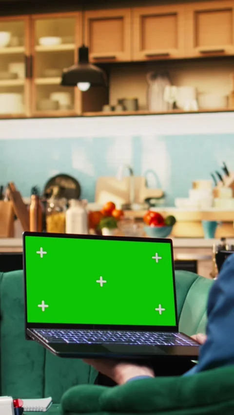 Vertical Video Isolated chroma key with aged man holding laptop in living room Stock Footage 329944075