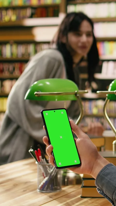 Vertical Video Isolated green screen on laptop near study group at library desk Stock Footage 336379754