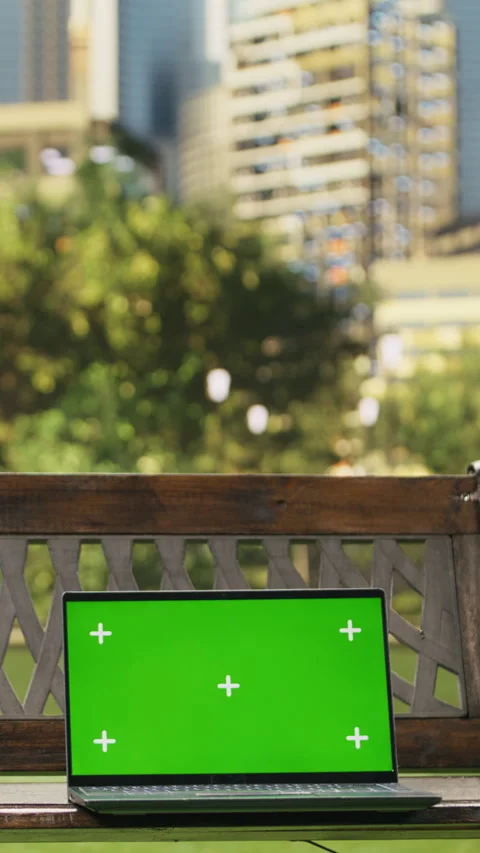 Vertical Video Isolated green screen on laptop placed on wooden bench in city Stock Footage 344375887