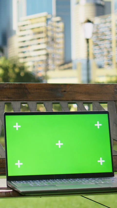 Vertical Video Isolated green screen on laptop placed on wooden bench in city Stock Footage 344381855