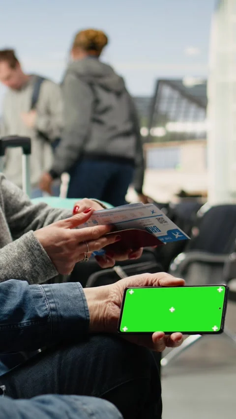 Vertical Video Isolated mockup smartphone held by older people in airport lounge Stock Footage 344373522