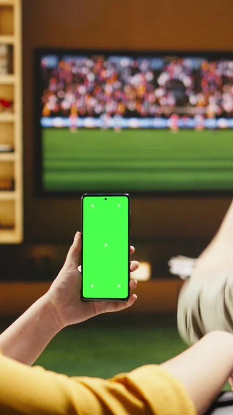 Vertical video Isolated screen phone used by woman watching football match Stock Footage 338185220