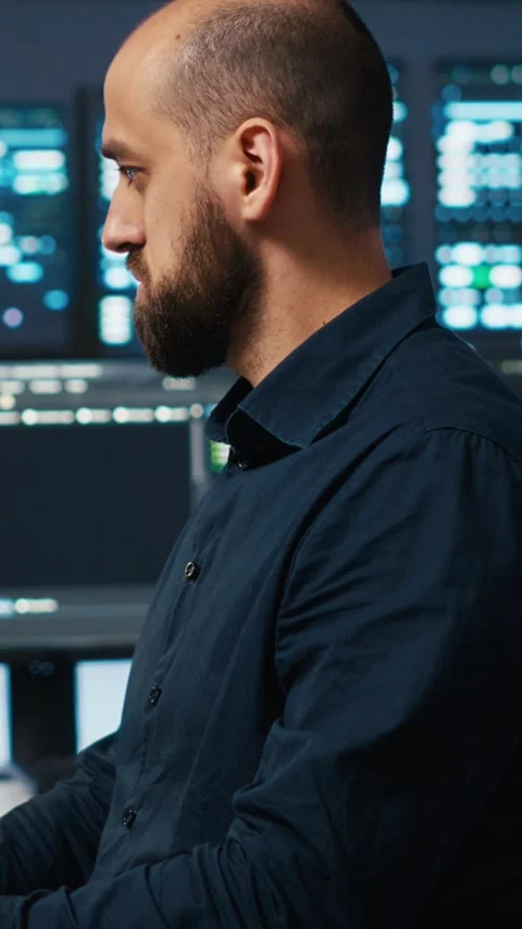 Vertical video IT engineer overseeing server room, running code, troubleshooting Stock Footage 274680090