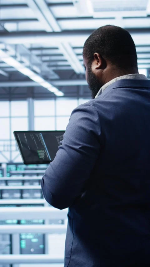 Vertical video IT expert in server hub facility looking for network bugs with Stock Footage 277854913