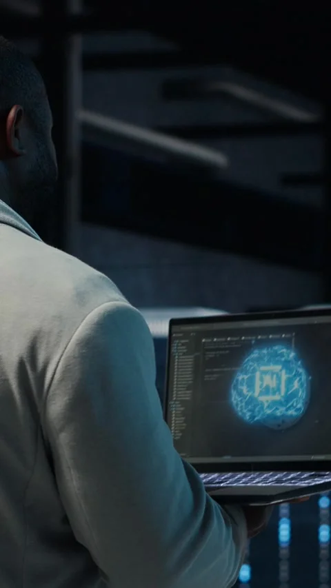 Vertical video IT expert walking in server hub using laptop to enhance AI model Stock Footage 311416761