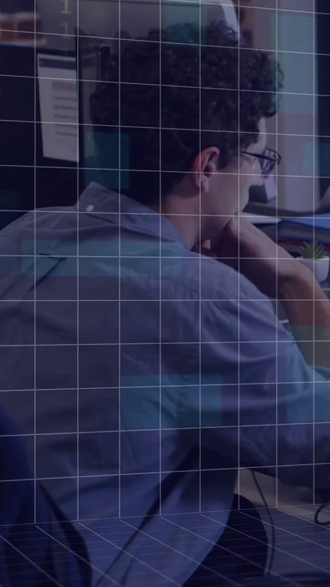 Vertical video: IT man leaning on hand, monitor casting binary grid over desk Stock Footage 334694938