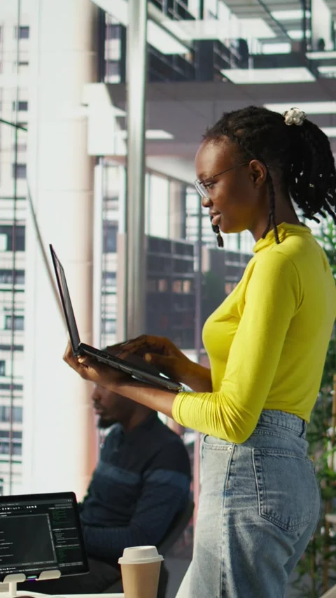 Vertical video IT staff member using laptop to do programming in office Stock Footage 319485326