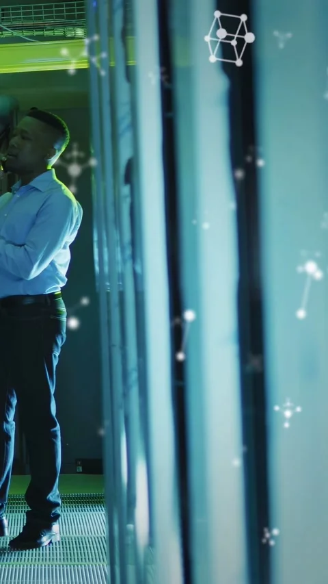 Vertical video: IT tech raising phone while checking server racks floating data Stock Footage 332823229