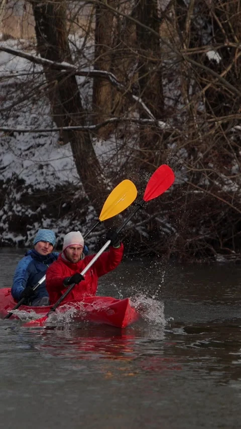 Vertical video. Kayakers navigating a winter river while enjoying an adventurous Stock-Footage 302959769