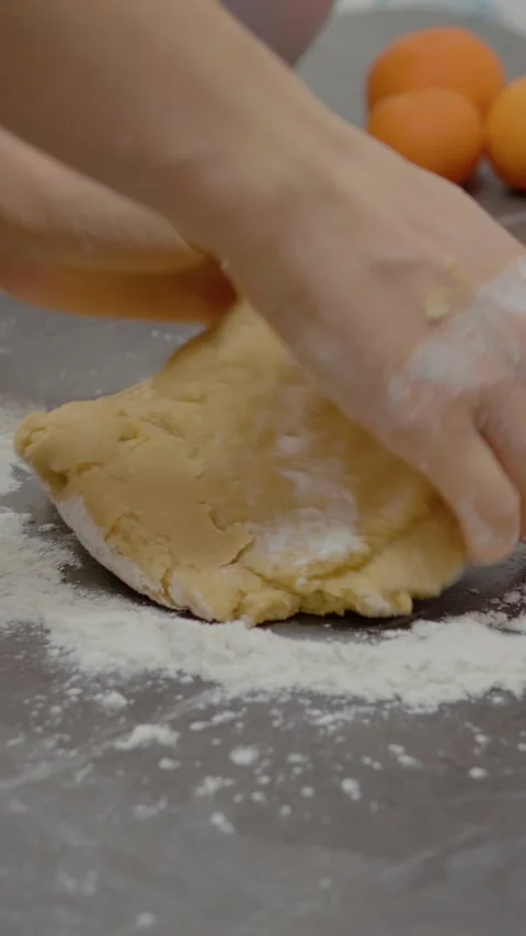 Vertical video Kneading cookie dough with hands on a kitchen counter Stock Footage 329629668