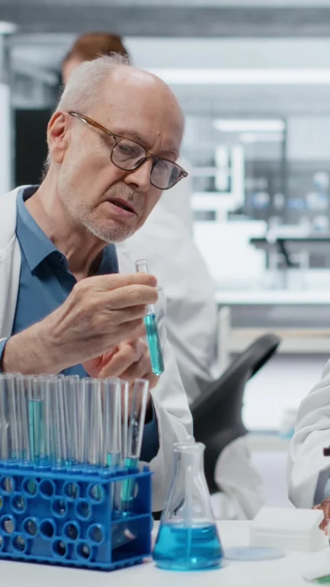 Vertical video Lab analytical chemists working together, investigating liquid Stock Footage 326830439