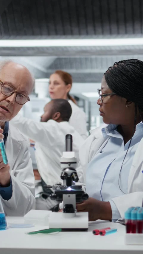 Vertical video Lab analytical chemists working together, investigating liquid Stock Footage 327416360