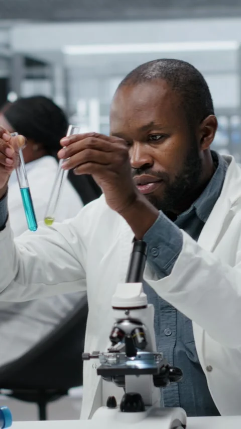 Vertical video Lab assay development specialist investigating blue liquid Stock Footage 326260452