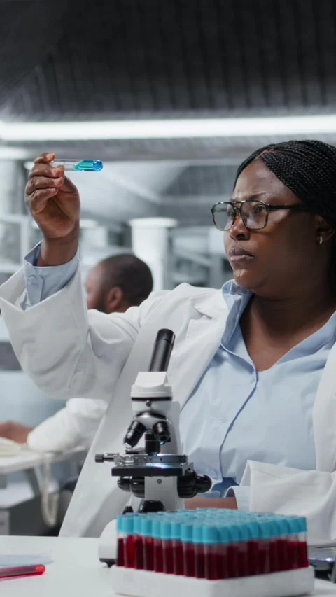 Vertical video Lab materials scientist investigates blue liquid polymer Stock Footage 326011854