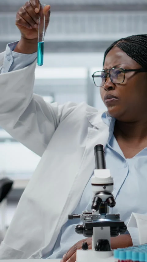 Vertical video Lab materials scientist investigates blue liquid polymer Stock Footage 327334355