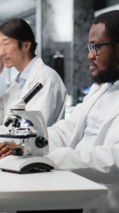 Vertical video Lab microbiologist using microscope for cellular analysis Stock Footage 319597364