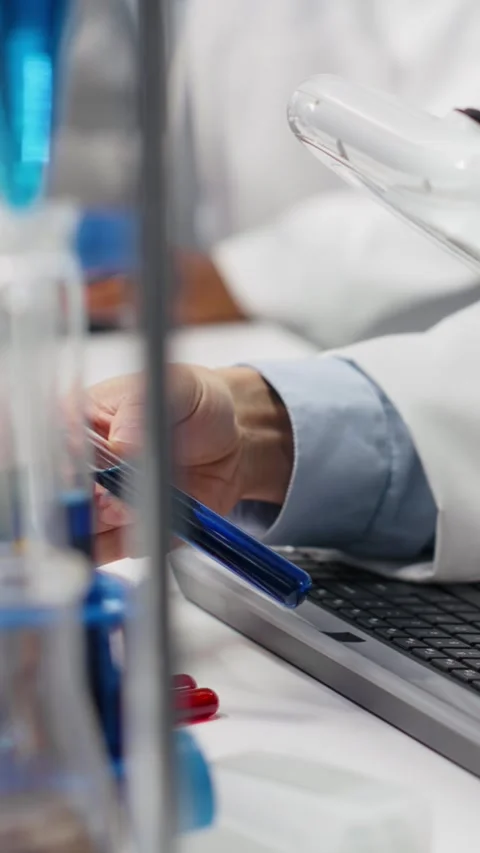 Vertical video Lab professional examines test tube sample under controlled Stock Footage 319506945
