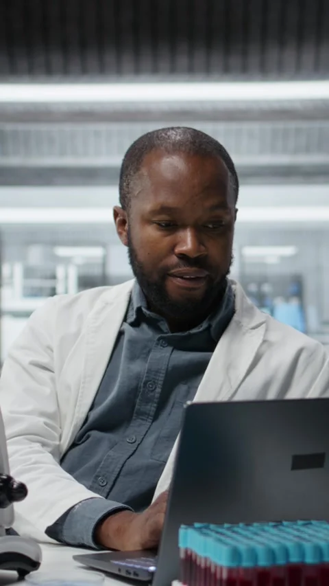 Vertical video Lab researcher using laptop software to evaluate compound Stock Footage 326366638