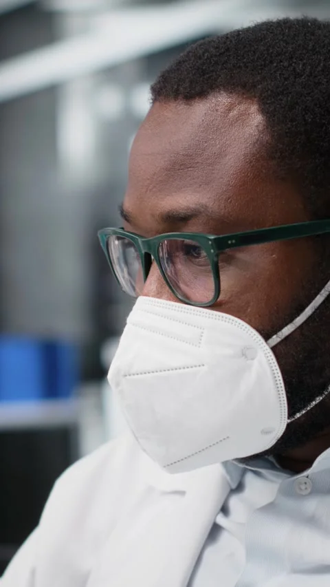 Vertical video Lab scientist removing protective face mask to scratch beard Stock Footage 319596905