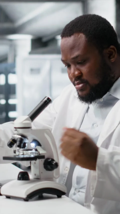 Vertical video Lab scientist using microscope to evaluate cellular structures Stock Footage 319506664