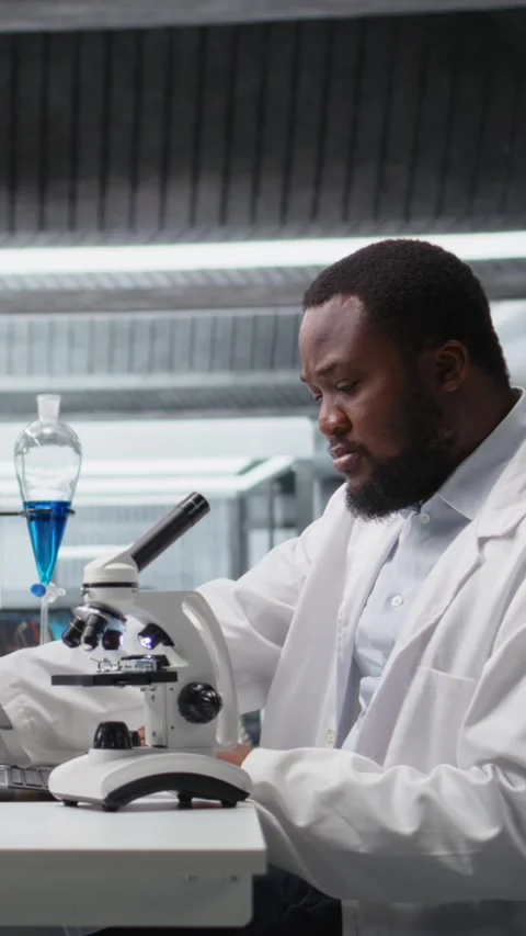 Vertical video Lab scientist using microscope to evaluate cellular structures Stock Footage 319506722
