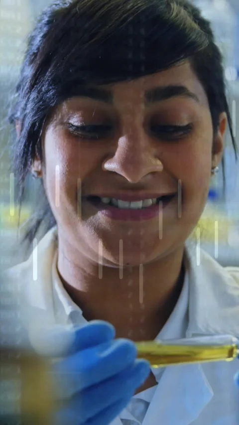Vertical video: Lab tech glancing left testing yellow test tube while data Stock Footage 330580683